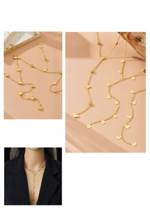Detail of gold-plated Y-shaped necklace featuring heart, butterfly, and flower charms