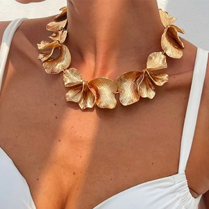 Macro shot of a golden floral statement necklace with textured wave metal petals