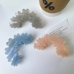 Close-up of wavy cloud acetate hair claws in pearlized grey, blue and pink colors