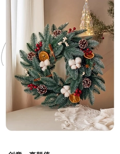 Detail of Christmas wreath with pine needles, cones, berries, cotton and orange slices