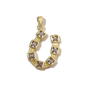 Detail of horseshoe pendant with gold plating and prong-set square cubic zirconia