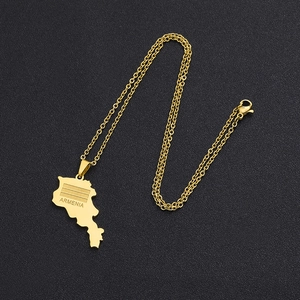 Gros plan détaillé du collier avec pendentif carte de l'Arménie doré sur fond noir