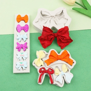 Macro shot of white silicone bow molds with colorful resin samples on a minimal background