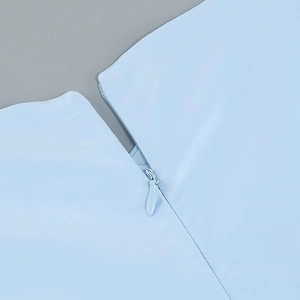 Detail shot of invisible zipper closure and knit fabric texture on light blue mini dress