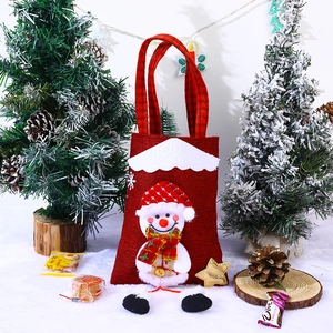 Close-up of red burlap Christmas bag featuring 3D snowman doll and checkered scarf