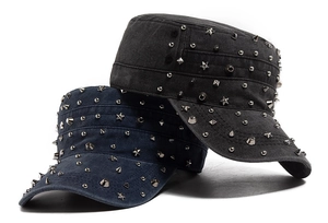 Close-up of vintage cadet caps featuring diverse metal studs and rivets on washed denim