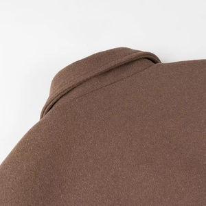 Gros plan sur le col d'une veste en laine marron montrant la texture et les détails du zip