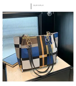 Dettaglio della borsa tote plaid color-block con motivi blu e tracolla a catena
