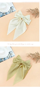 Close-up of double-layered satin bow hair clips in beige and olive green colors