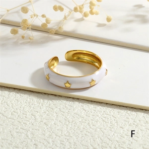 Detail of white enamel open ring with gold star patterns and 18K gold plated interior