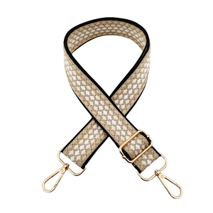 Detail of adjustable woven shoulder strap with geometric pattern and gold metal hooks