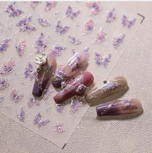 Macro view of purple and pink 3D embossed butterfly nail stickers with silver edges