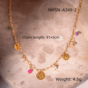 Detail view of gold necklace with colorful beads, white pearls and hammered coin charms