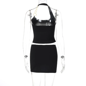 Détail du haut dos nu noir avec chaînes dorées et mini-jupe assortie sur un mannequin