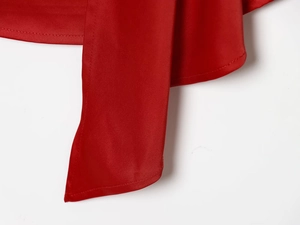 Detail view of the red satin fabric tie and smooth glossy texture on the shirt