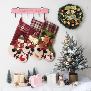 Detail of Christmas stocking set with 3D snowman, Santa and reindeer hanging on festive wall