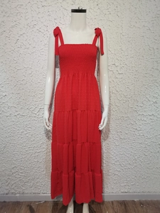 Detail of red tiered dress featuring pleated chest design and shoulder ribbon bow ties