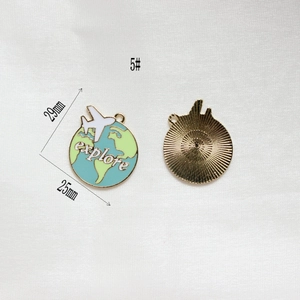 Detail of blue earth and plane charm showing explore text and 25x29mm dimensions
