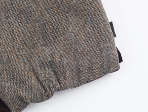 Detailed macro view of multi-color tweed fabric texture on a winter padded vest