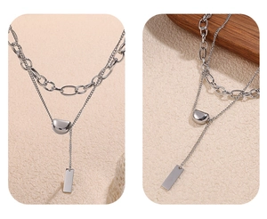Detail of layered silver stainless steel necklace with D-shaped and rectangle pendants