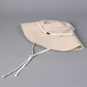 Detail of off-white sun hat showing adjustable windproof drawstring and quick-dry fabric