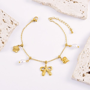 Gouden armband met strik, parel, hart en bloembedels op minimalistische stenen decor