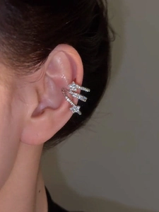 Close-up of a silver multi-layered ear cuff with zircon stars on a model's ear