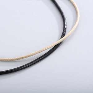 Close-up of black and beige braided leather cord necklaces with fine woven texture detail