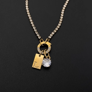 Dettaglio del ciondolo lettera L placcato oro 14K e zircone su catena tennis scintillante