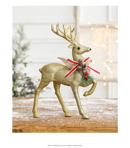Golden glitter reindeer figurine with pine cone detail on a snowy wooden surface