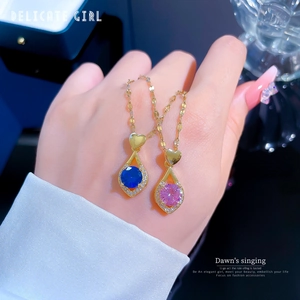 Colliers en acier titane avec pendentifs cœur et pierres roses et bleues en main