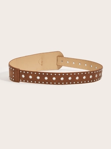Detail view of brown punk belt with silver metal eyelets and rivets on a cream background