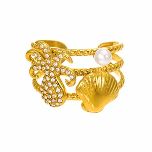 Detail of gold stainless steel ring with zircon palm tree, scallop and shell bead