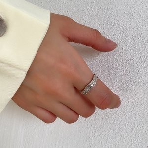 Detail view of irregular pleated S925 sterling silver ring showing wavy metal texture