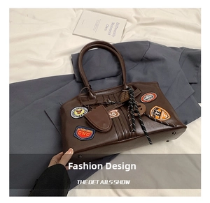 Detaillierte Nahaufnahme der dunkelbraunen Vintage-Ledertasche mit Patches und Kordelzug