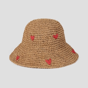 Close-up of woven straw hat featuring red embroidered hearts and textured sun protection