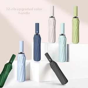 Close-up of modern folding umbrellas in various colors displayed on white geometric steps