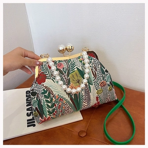 Nahaufnahme der floralen Stickerei einer Vintage-Handtasche mit Perlen griff und Metallverschluss