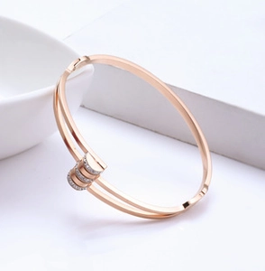 Macro detail of rose gold C-shaped magnetic bracelet with sparkling zircon inlay design