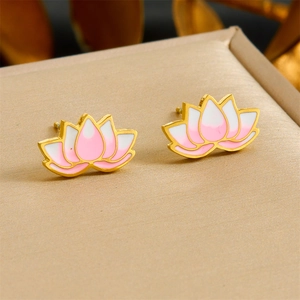 Macro shot of gold-plated lotus earrings with pink and white enamel petals