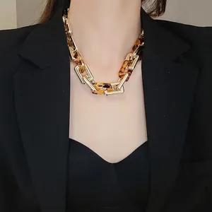 Collana a catena leopardata con anelli dorati su una modella con un completo nero