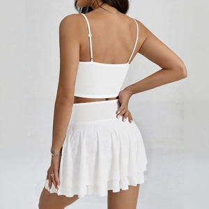 Rear view of white lace patchwork crop top and pleated mini skirt set for vacation