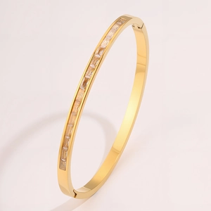 Detailed close-up of a gold titanium bracelet featuring rectangular zircons inlay