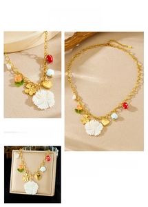 Détail du collier plaqué or avec pendentifs fraise cœur et fleurs en coquillage
