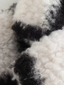 Macro shot showing high-quality black and white checkered faux fur texture on long coat
