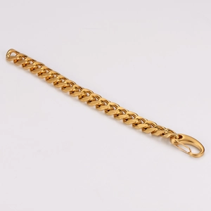 Detailed close-up of a gold Cuban link chain bracelet for men with high polished finish