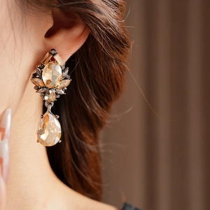 Close-up of vintage champagne crystal drop earrings on a model with bronze setting