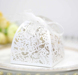 Detail of white laser-cut hollow wedding favor box with an elegant ribbon bow tie