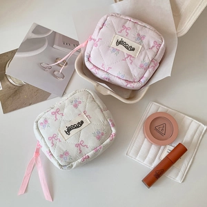 Detailed view of quilted small cosmetic bags in pink and white with floral patterns