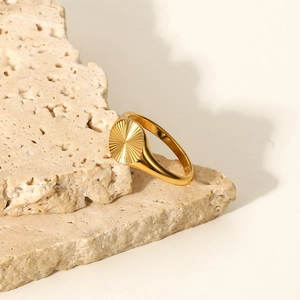 Détail d'une bague empilable plaquée or 18 carats avec texture soleil sur pierre